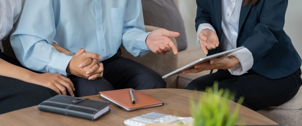 A couple sits eagerly in front of a lawyer, delving into the specifics of Texas common law marriage eligibility criteria to understand their own standing.