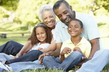 Grandparents enjoy a serene picnic with their grandchildren, a scene that subtly underscores the legal nuances of grandparent custody rights.