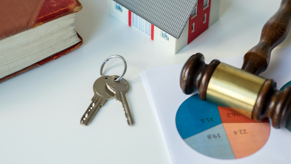 House keys, a business chart, and a gavel lay scattered on a table, symbolizing the intricate assets involved in high net worth divorce cases.