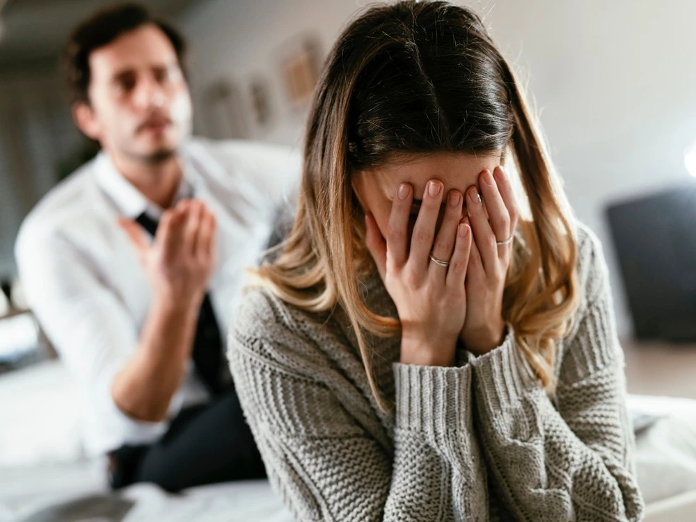 A couple caught in a heated argument, with the woman in tears, starkly illustrates the devastating impact of emotional and psychological abuse.