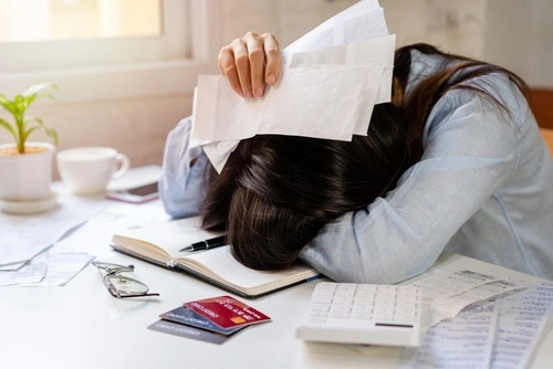 A snapshot of a person visibly overwhelmed by a pile of legal documents related to health insurance and divorce