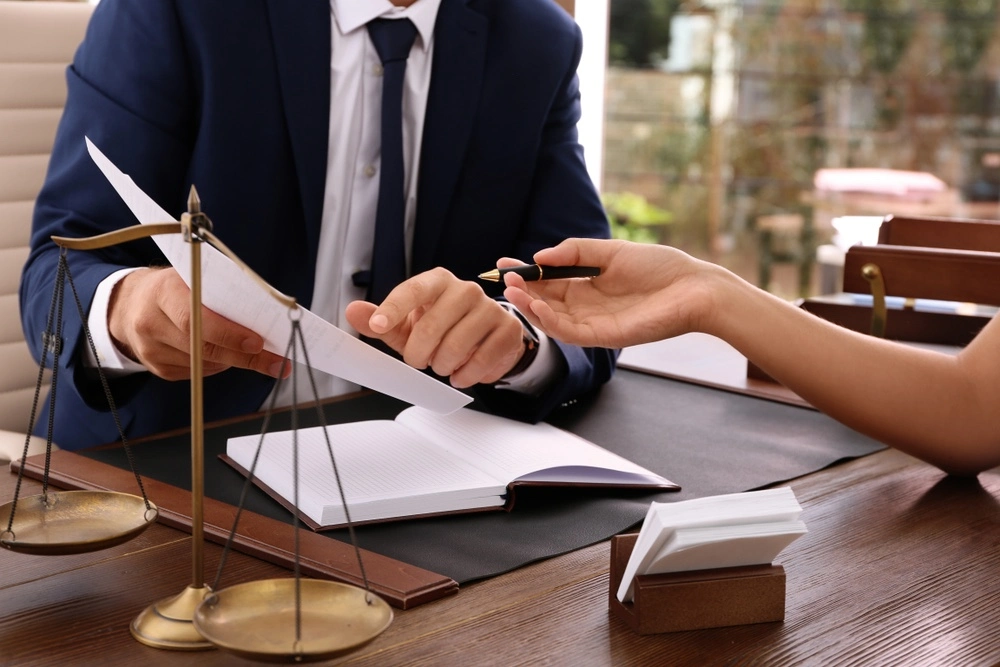 A client and lawyer sit together, poring over documents as they discuss the differences between uncontested and contested divorce forms in Texas.