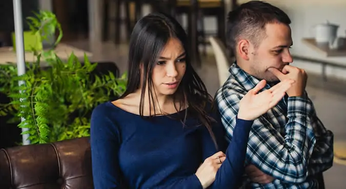 Couple sitting back to back, looking away from each other