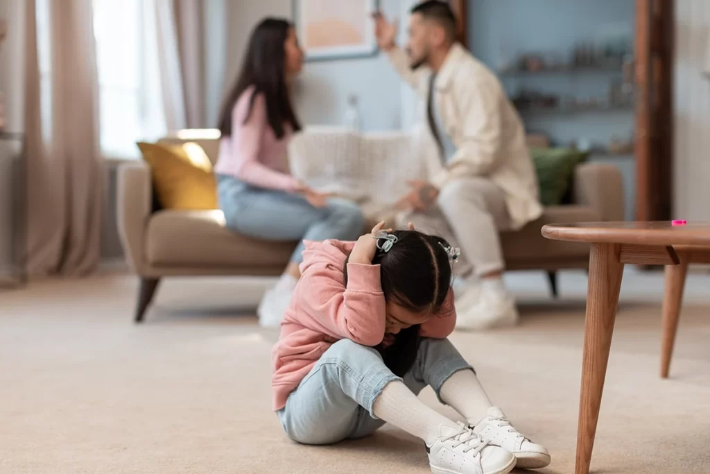 asian-baby-covering-ears-while-angry-parents-fight