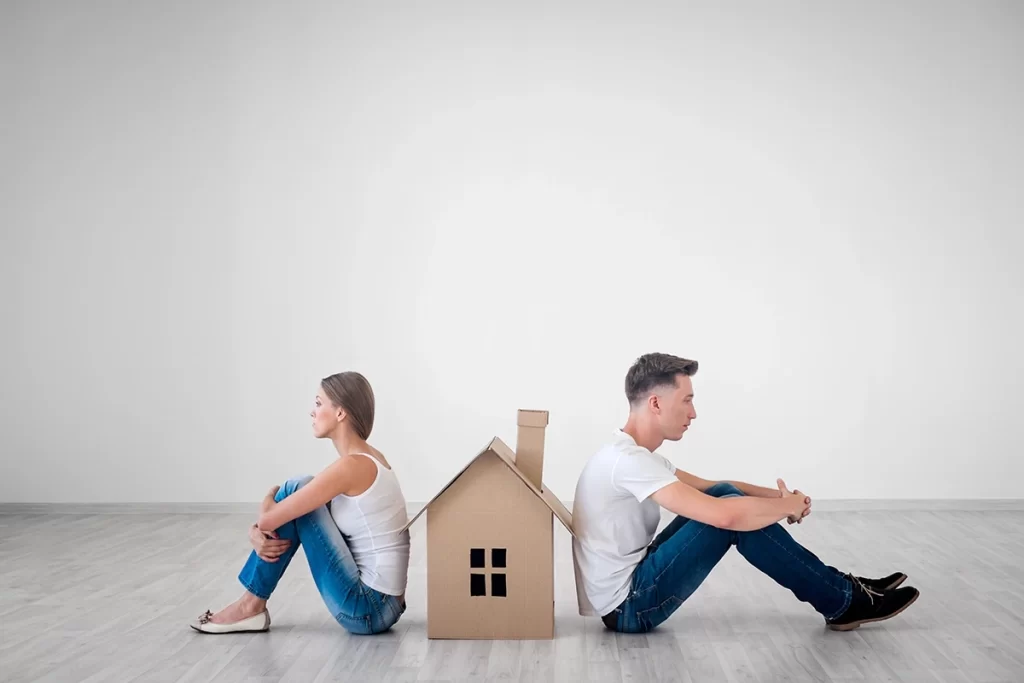 upset-couple-with-house-model-in-between-them